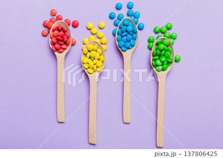 delicious colorful sweet candies on spoon on colored background . Confectionery decor top view with copy space 137806425