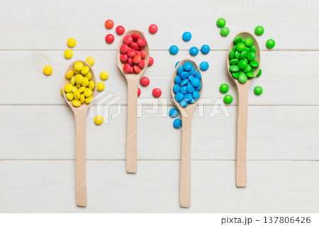delicious colorful sweet candies on spoon on colored background . Confectionery decor top view with copy space delicious colorful sweet candies on spoon on colored background . Confectionery decor top view with copy space 137806426