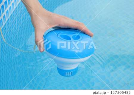 Worker hands isinfection and chlorination of water in the pool. Purification from pollution pool chlor dispenser 137806483