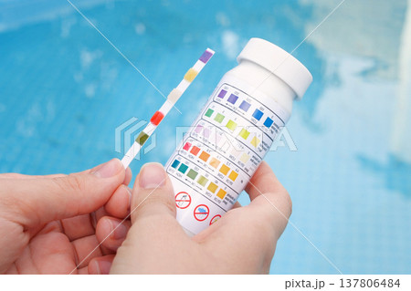Analysis of the PH and chlorine of the water in a swimming pool in Summer. Check quality of water with test strip, comparing results 137806484