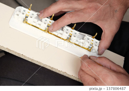 man making an extension cord socket outdoor man making an extension cord socket outdoor 137806487