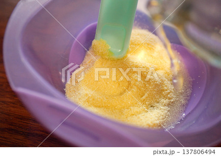 baby food and nutrition concept - mother hands with jar, spoon and bowl preparing cereal from powder close up 137806494