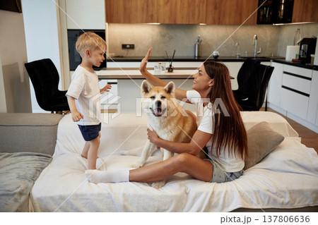 High five hands gesture. Mother with son and Shibu Inu dog are at home High five hands gesture. Mother with son and Shibu Inu dog are at home 137806636