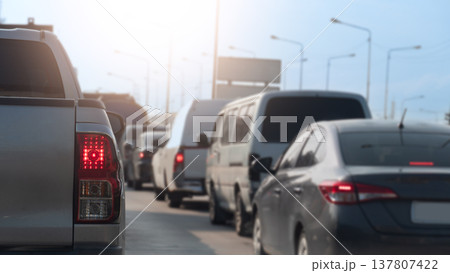 Rear side of pickup car driving on the road. With turn on brake light with many cars stop by traffic jam. Under blue and bright sky. 137807422