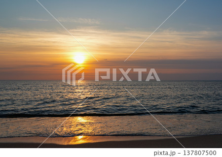 Golden Sunset Over Baltic Sea with Gentle Waves and Warm Evening Light on Sandy Beach Horizon Golden Sunset Over Baltic Sea with Gentle Waves and Warm Evening Light on Sandy Beach Horizon 137807500