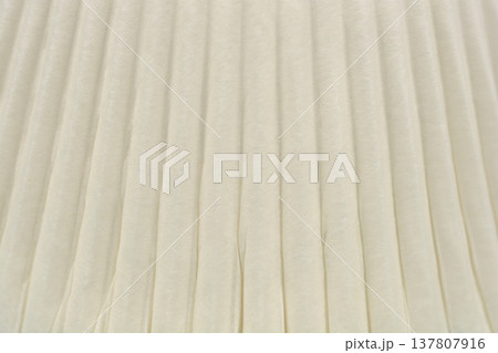 Close up texture of a white pleated paper cupcake liner Close up texture of a white pleated paper cupcake liner 137807916