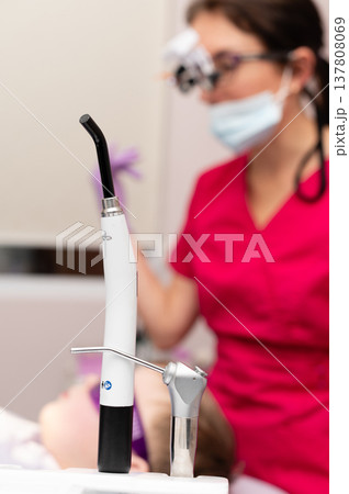 Dental professional assists young patient in a bright clinic, focusing on oral care techniques while ensuring comfort and safety during the procedure 137808069