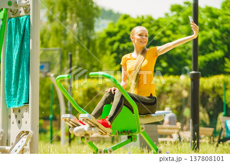 Girl doing exercises outdoor, taking selfie Girl doing exercises outdoor, taking selfie 137808101