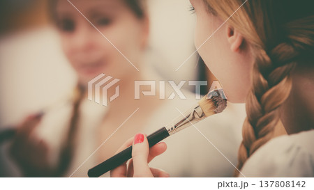 Woman applying with brush clay mud mask to her face Woman applying with brush clay mud mask to her face 137808142