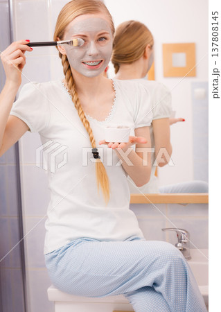 Woman with grey clay mud mask on her face Woman with grey clay mud mask on her face 137808145