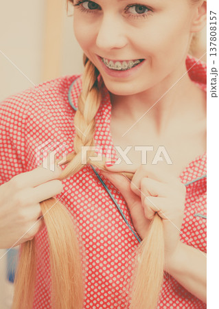 Woman doing braid on blonde hair 137808157