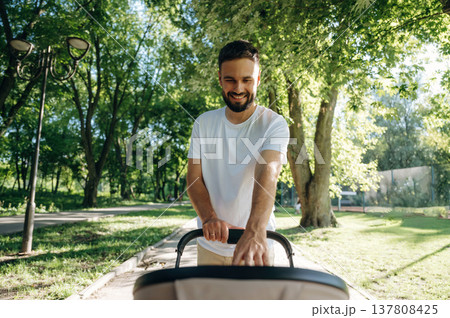 Taking care of baby, looking into a cradle. Father is having a walk in the park 137808425
