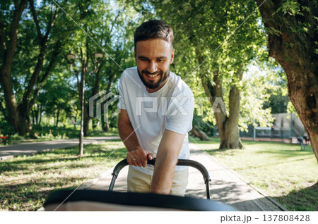 Very happy, parenting conception. Father is with cradle, having a walk in the park Very happy, parenting conception. Father is with cradle, having a walk in the park 137808428
