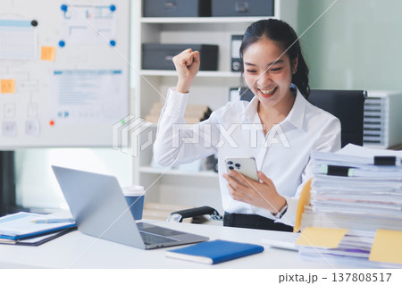 Charming smiling adult woman middle aged woman with curly hair architect designer working on computer in the bright modern office 137808517