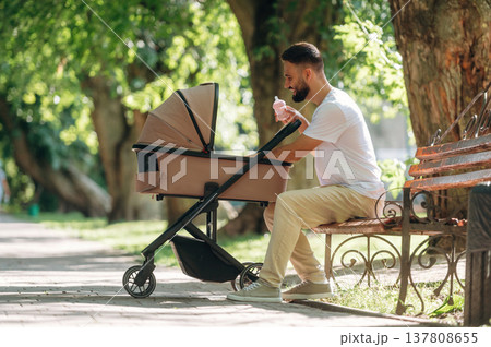 Father is with cradle, having a walk in the park Father is with cradle, having a walk in the park 137808655