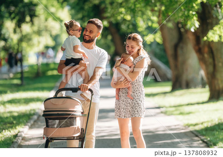 Care conception, holding baby. Couple is with daughter, newborn baby and cradle are having a walk 137808932