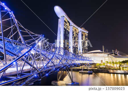 Night view of The Helix Bridge and the Marina Bay Sands Resort, Singapore, it's a pedestrian bridge linking the Marina Centre with Marina South. Night view of The Helix Bridge and the Marina Bay Sands Resort, Singapore, it's a pedestrian bridge linking the Marina Centre with Marina South. 137809023