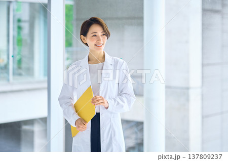 病院の廊下で笑顔を見せる白衣の日本人女性 医師 薬剤師 研究員 病院の廊下で笑顔を見せる白衣の日本人女性 医師 薬剤師 研究員 137809237