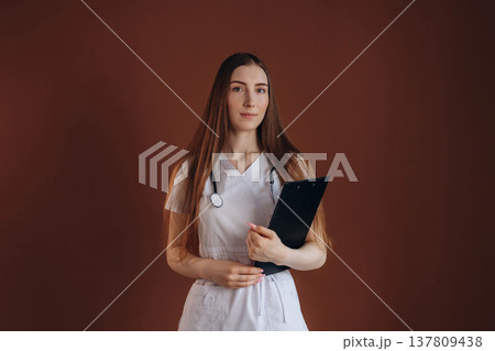 Notepad is in hand. Female doctor is in the studio 137809438