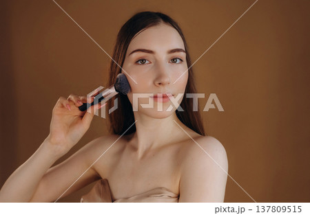 Make up, cosmetics conception. Young woman is against background Make up, cosmetics conception. Young woman is against background 137809515