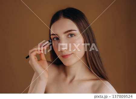 Make up, cosmetics conception. Young woman is against background Make up, cosmetics conception. Young woman is against background 137809524