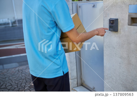 宅急便を自宅に届ける配送業者の男性 宅急便を自宅に届ける配送業者の男性 137809563