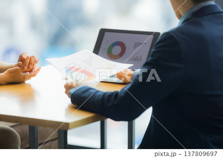 カフェで働く女性と打ち合わせるスーツの男性　 137809697