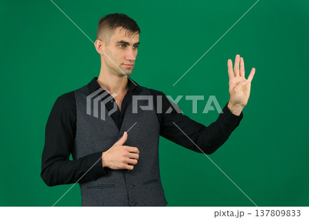 Various emotions and movements of a man in a gray suit on a green background in a vest and pants, many different poses 137809833