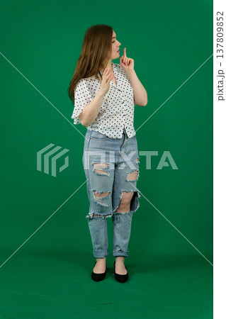 Various emotions and movements of a woman in a pink shirt and black pants on a green background. A European woman with a round face. Various poses. 137809852