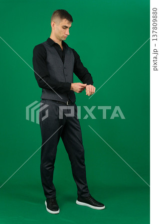 Various emotions and movements of a man in a gray suit on a green background in a vest and pants, many different poses 137809880