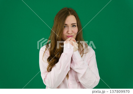 Various emotions and movements of a woman in a pink shirt and black pants on a green background. A European woman with a round face. Various poses. Various emotions and movements of a woman in a pink shirt and black pants on a green background. A European woman with a round face. Various poses. 137809970
