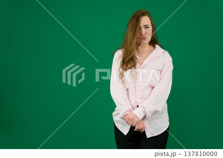 Various emotions and movements of a woman in a pink shirt and black pants on a green background. A European woman with a round face. Various poses. Various emotions and movements of a woman in a pink shirt and black pants on a green background. A European woman with a round face. Various poses. 137810000