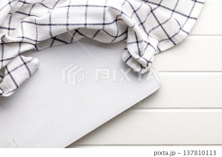 White Cutting Board With Checkered Kitchen Towel On Rustic White Wooden Background, Flat Lay 137810113