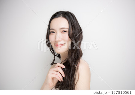 白背景に綺麗な黒髪をなびかせるロングヘアでパーマの女性 ヘアケアやトリートメントイメージ カメラ目線 白背景に綺麗な黒髪をなびかせるロングヘアでパーマの女性 ヘアケアやトリートメントイメージ カメラ目線 137810561