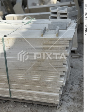 Stack of stone tiles outdoors at construction site, useful as textured background for projects 137810656