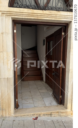 Open wooden door leading to staircase in narrow entryway of residential building Open wooden door leading to staircase in narrow entryway of residential building 137810670