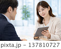 タブレットを見せながら説明する女性マネージャー 137810727