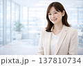 明るいオフィスで自信ある笑顔を見せる女性会社員ポートレート 137810734