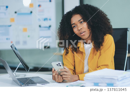Pretty female freelancer working on laptop while sitting on modern coworking background 137811045