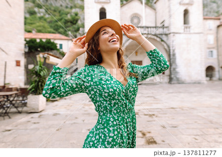 Happy female tourist in beautiful dress walking in the street of the city. Fashion style. 137811277