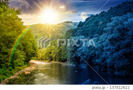 river flowing through green forest at the foot of mountain scenery. day meet night. sun and moon over picturesque landscape of countryside in summer. nature picture with stones on shore and cloudy sky 137812622