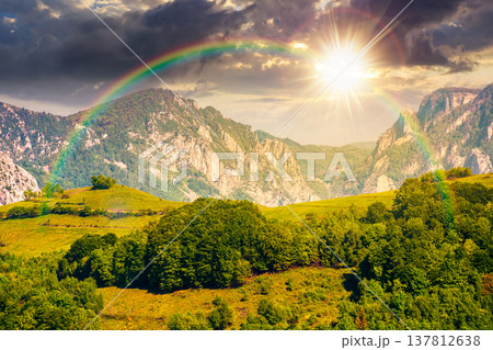 sunset over beautiful countryside. sunset over beautiful countryside. wonderful springtime landscape in mountains. grassy field and rolling hills. rural scenery with steep forested slopes. amazing 137812638