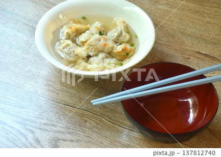 Chinese dumpling topping slice red barbecue pork with clear soup on bowl 137812740