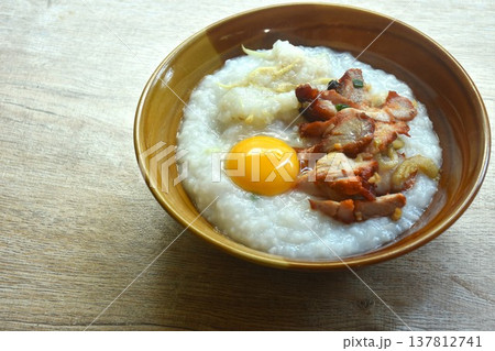 congee or rice porridge soup topping sweet red barbecue pork and egg yolk on bowl 137812741