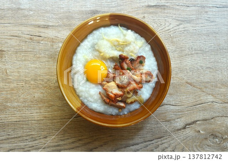 congee or rice porridge soup topping sweet red barbecue pork and egg yolk on bowl congee or rice porridge soup topping sweet red barbecue pork and egg yolk on bowl 137812742