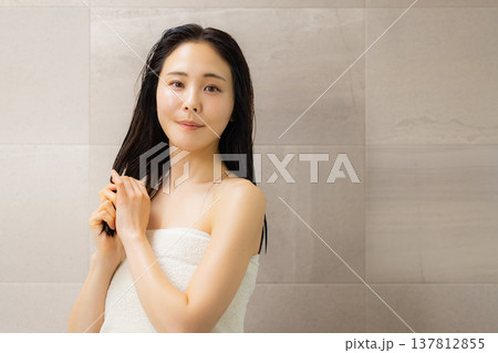 洗面所でヘアケアをする女性　　 137812855