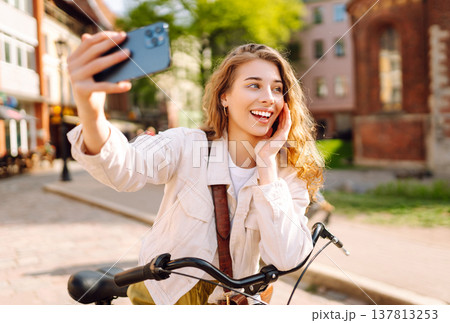 Young woman using mobile phone at the city. Telecommunications, video call conference. Selfie time. Young woman using mobile phone at the city. Telecommunications, video call conference. Selfie time. 137813253