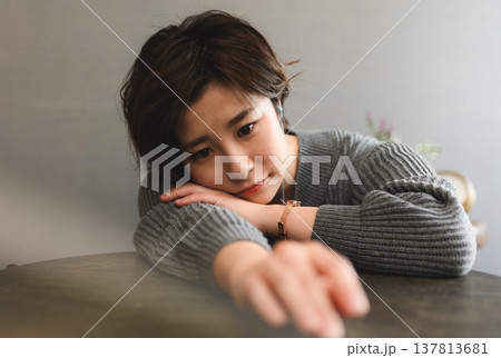 テーブルに肘をつく女性 テーブルに肘をつく女性 137813681