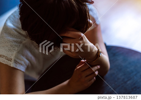 机にうつ伏せで悩む女性 137813687