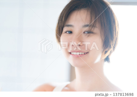 明るい光の中で微笑むショートヘアの女性 明るい光の中で微笑むショートヘアの女性 137813698
